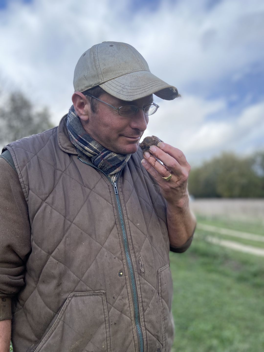 jeune homme humant le parfum enivrant d'une véritable truffe noire du périgord fraichement récoltée